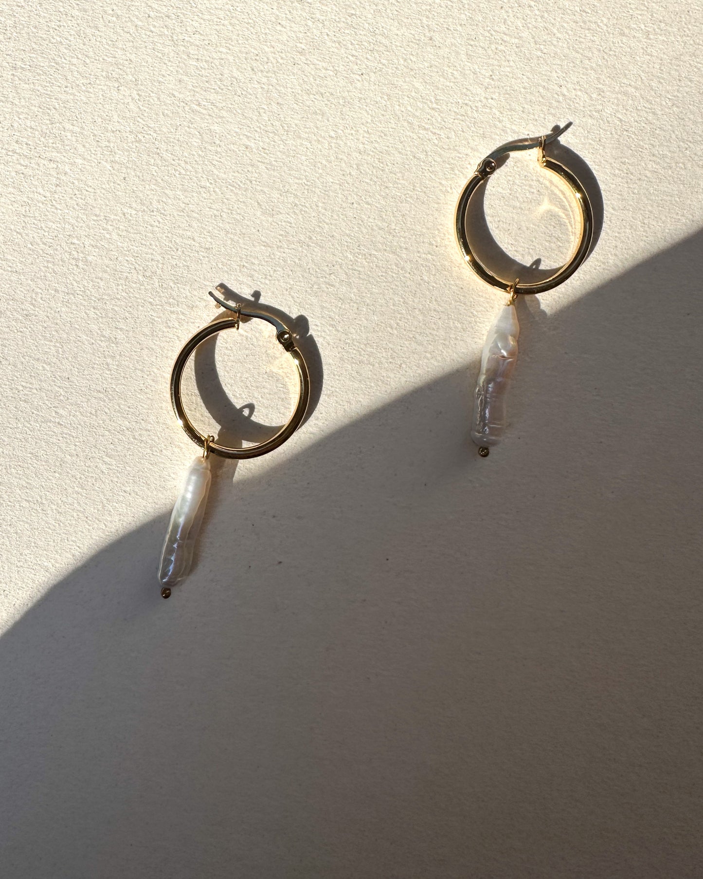 Aros bañados en oro con perlas largas.