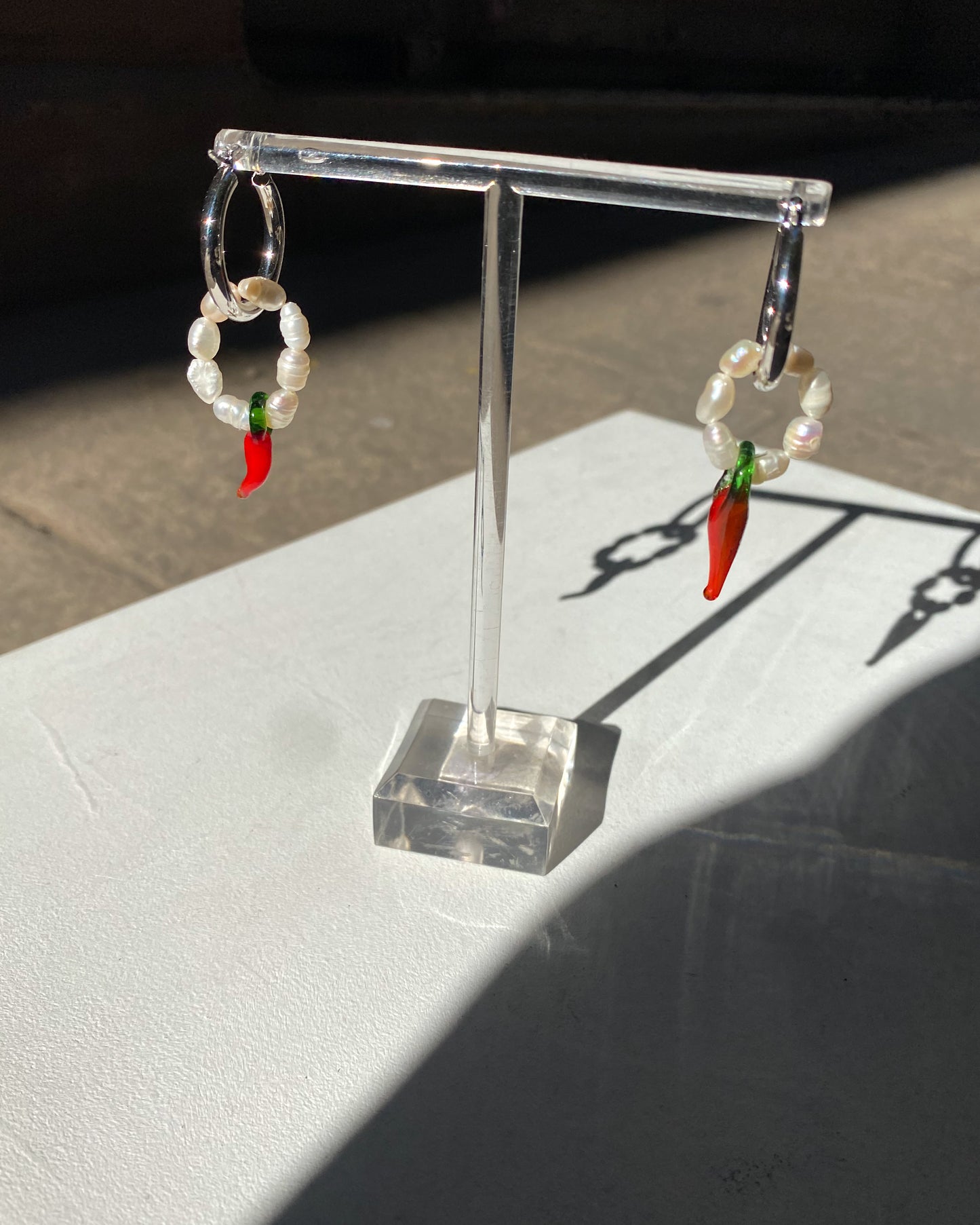 Pendientes de aro con perlas y chile.