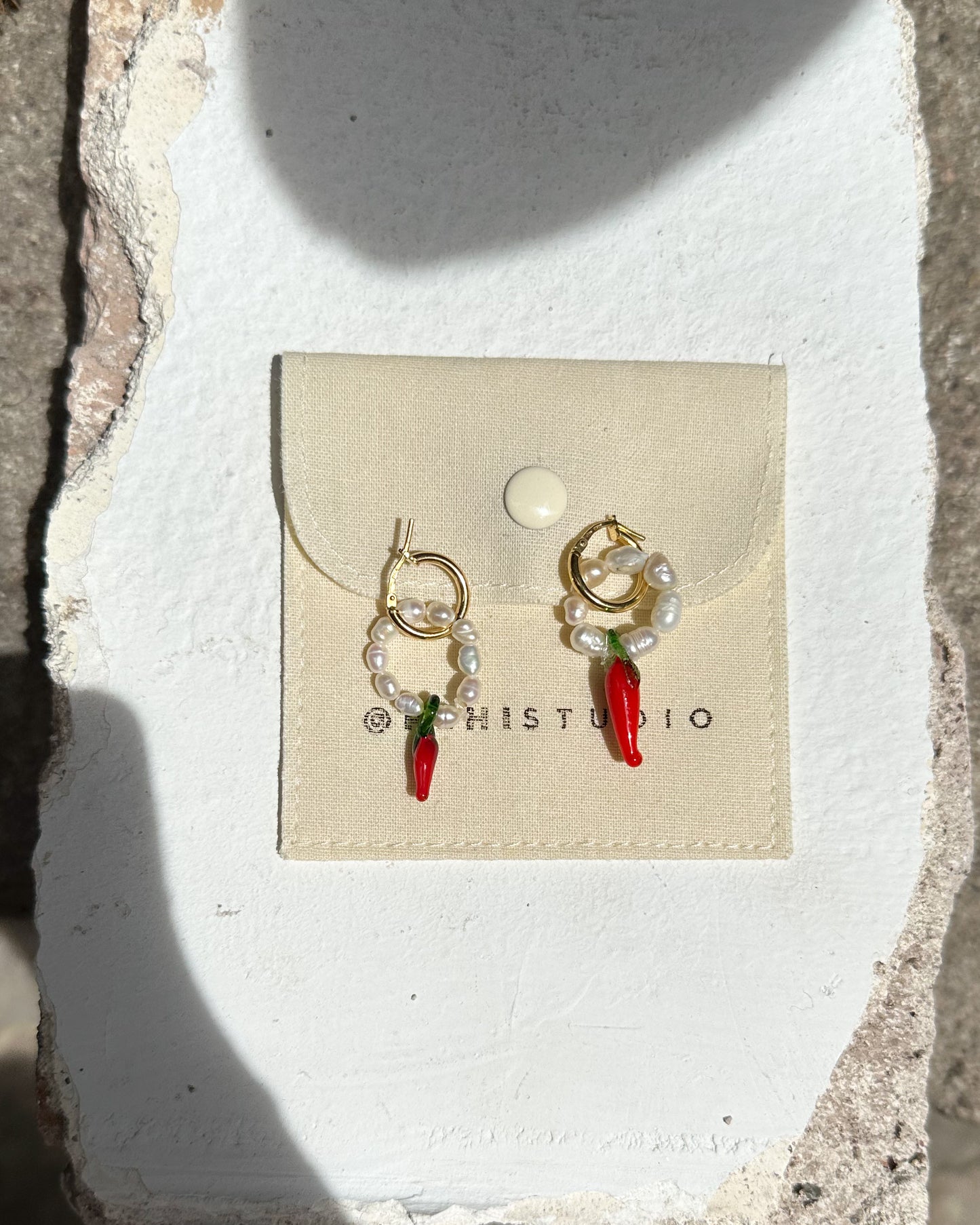 Pearls and chili hoop earrings.